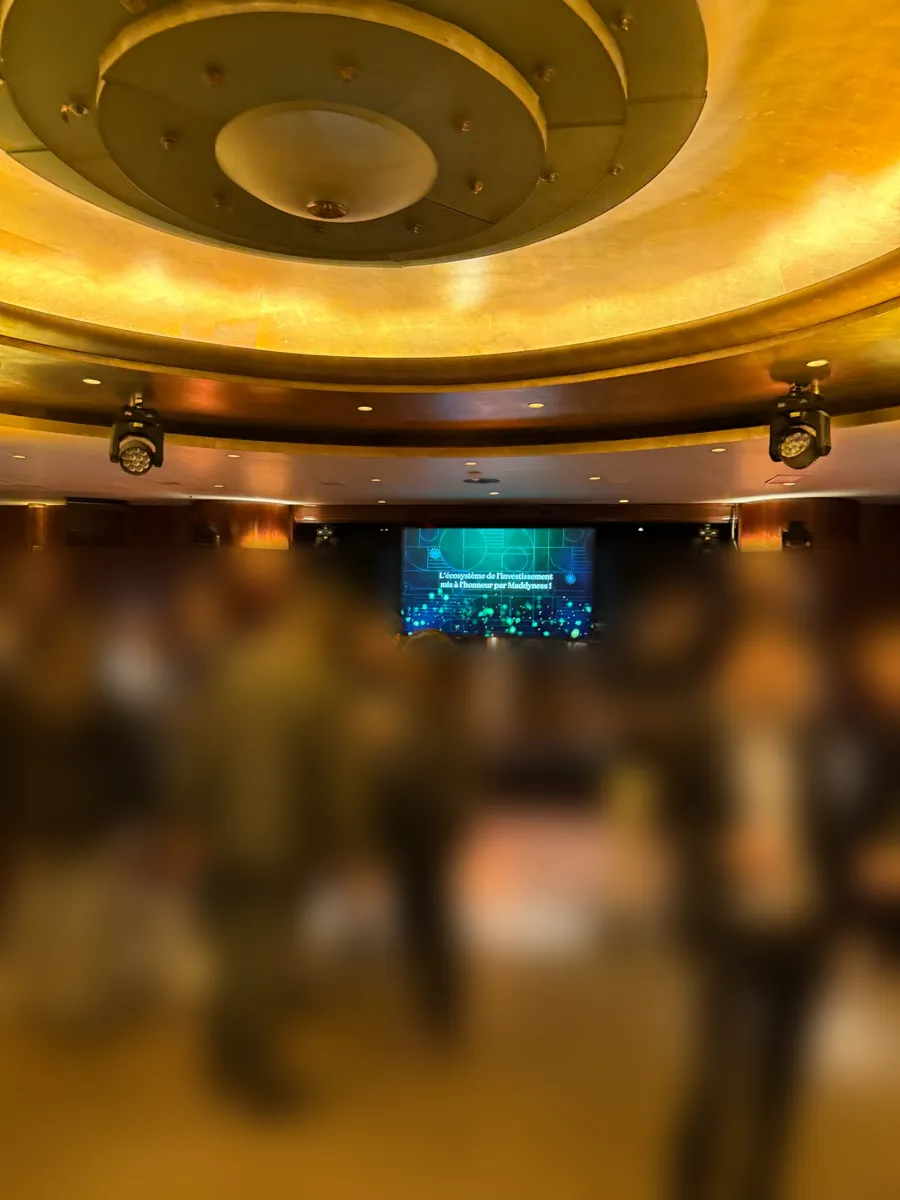 Écran Samsung 85 pouces sur pied dans une salle de réception, lumières asservies au plafond